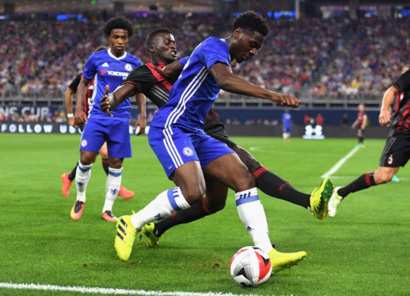 Ola Aina battling against AC Milan's M'baye Niang during pre-season.