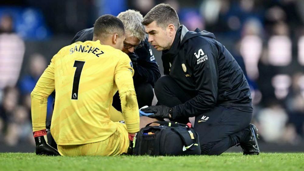 Robert Sanchez down injured on the pitch at Stamford Bridge.