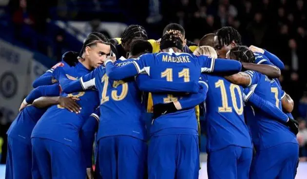Chelsea celebrate in a huddle.