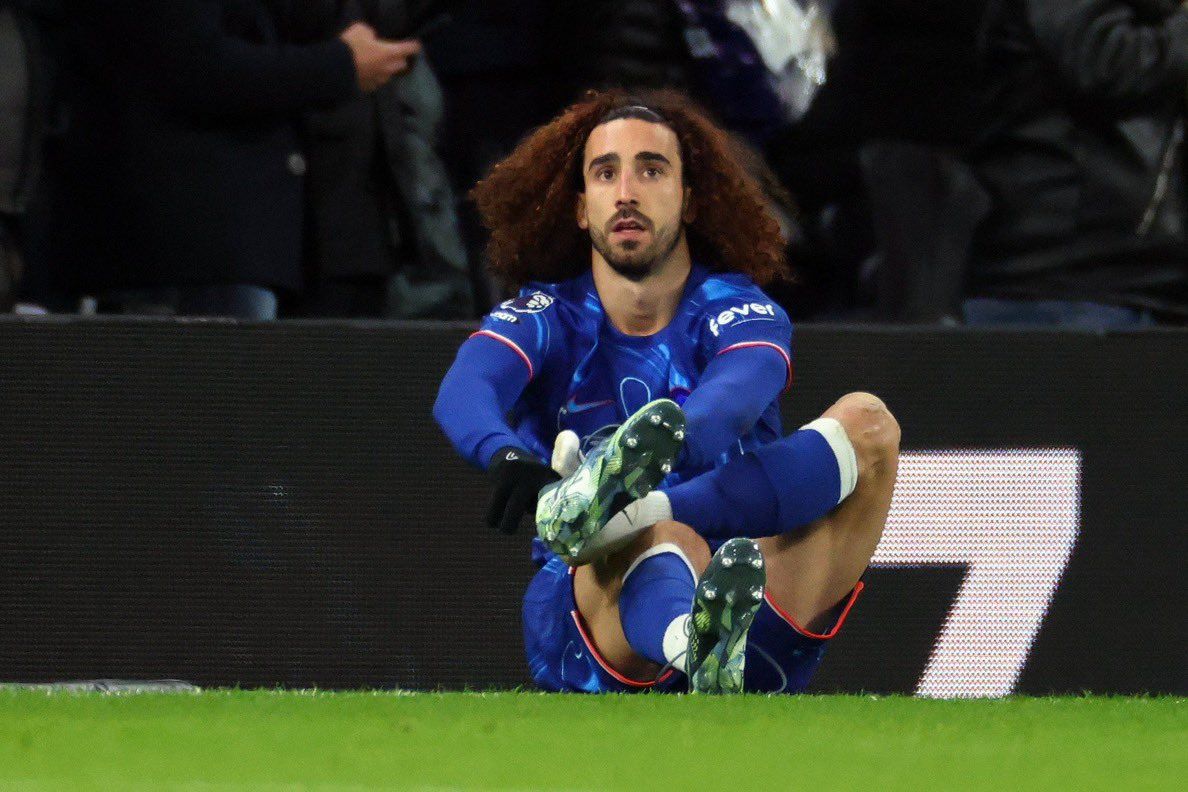 Marc Cucurella changes his boots on the sideline after slipping twice against Tottenham.