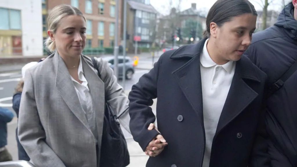Sam Kerr enters court with fiancÃ©e Kristie Mewis.