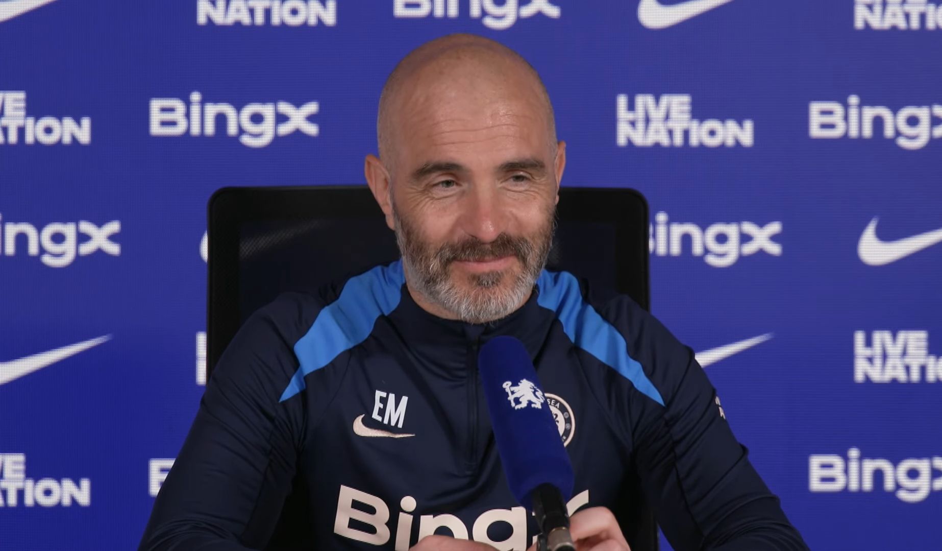 Enzo Maresca smiles in a press conference.