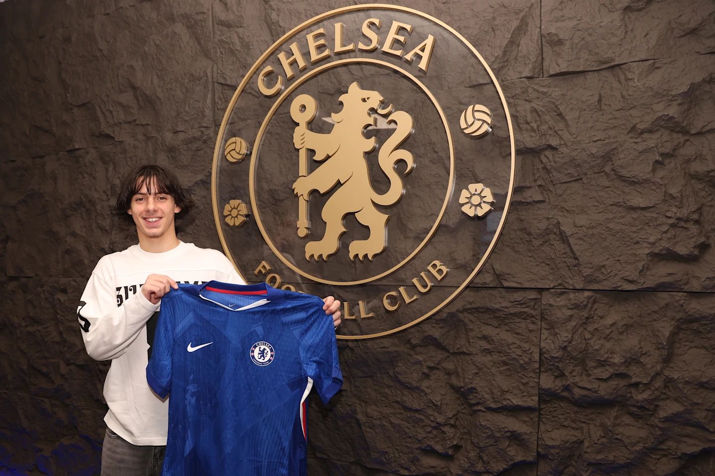 Ibrahim Rabbaj holds up Chelsea shirt.