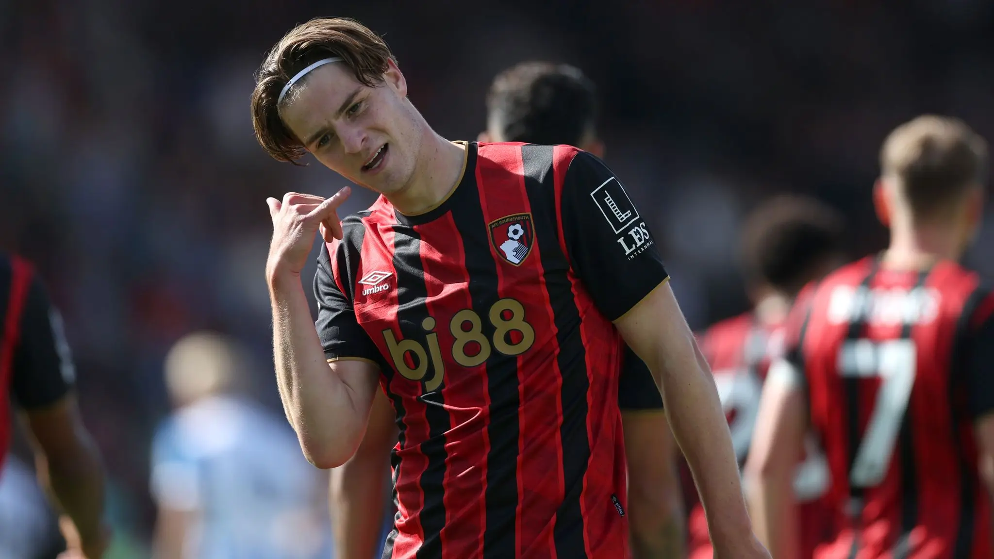Bournemouth football player celebrating on the pitch in team colors.