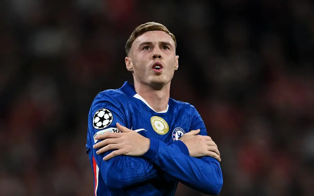 Chelsea player in blue jersey reacts during a match with Champions League emblem
