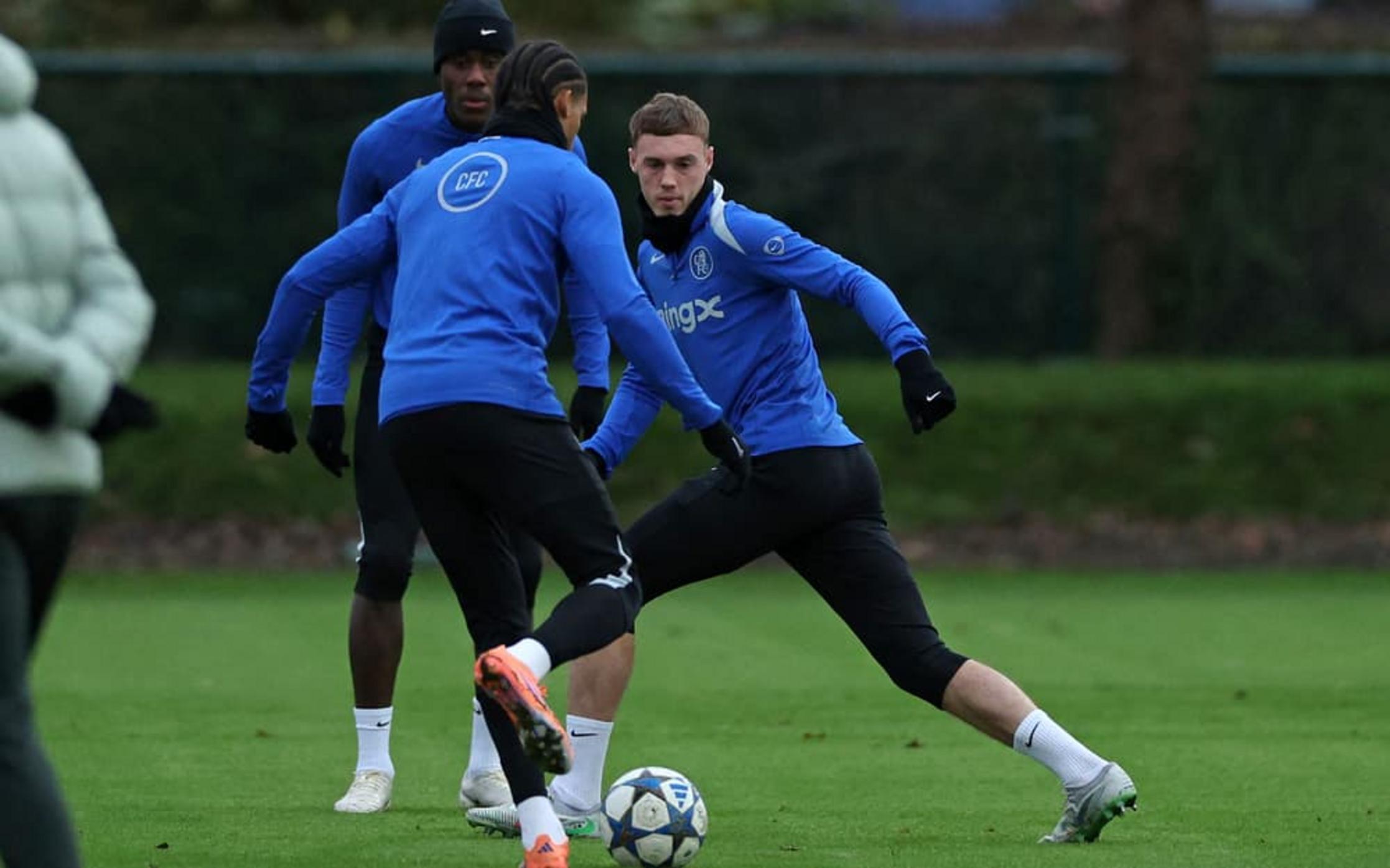 Cole Palmer training with Chelsea teammates in blue training kits on a pitch.