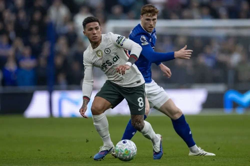 Enzo Fernandez in Chelsea kit dribbling the ball during a match against Everton.