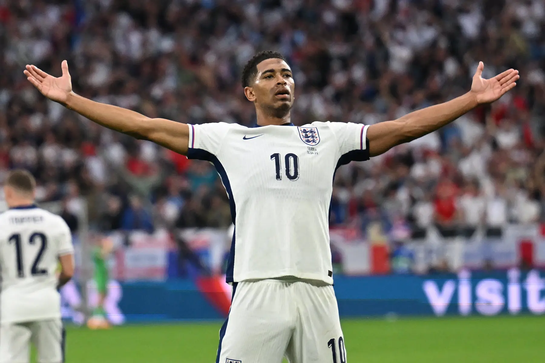 Jude Bellingham celebrating during an England football match in a white kit with the number 10.