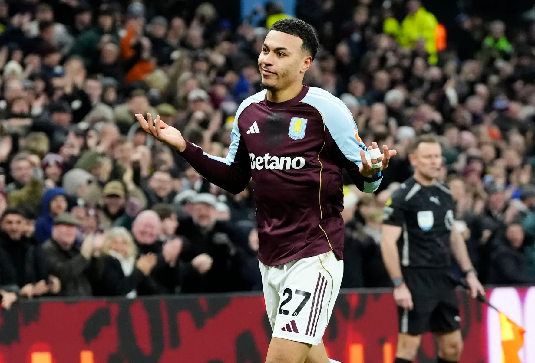 Morgan Rogers celebrating on the field in Aston Villa kit during a match.