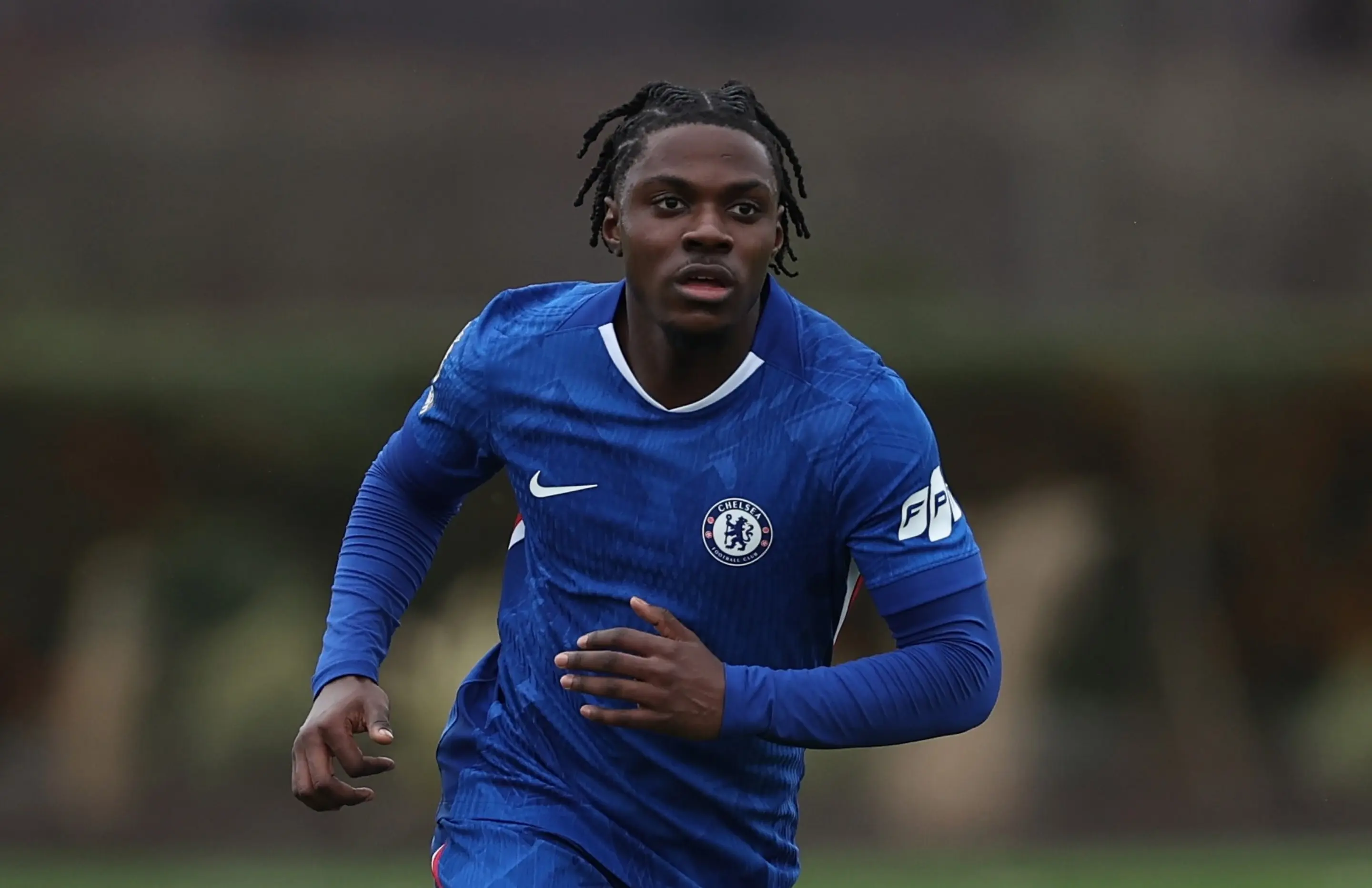 Romeo Lavia in a Chelsea FC jersey running during a training session.
