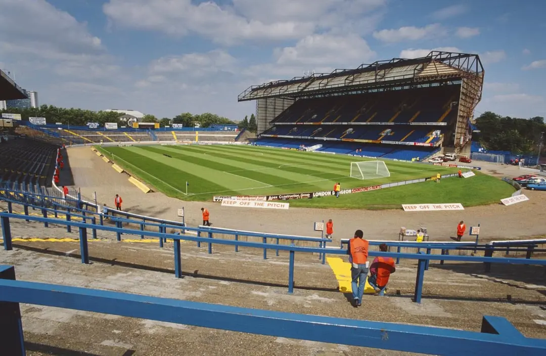 View of Stamford Bridge stadium in the 1990s, featuring fans and the pitch.