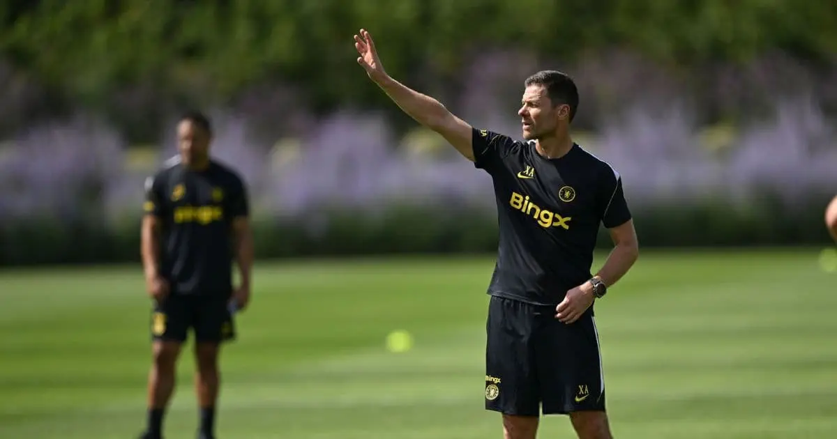 Football training session featuring a manager directing players on the field.