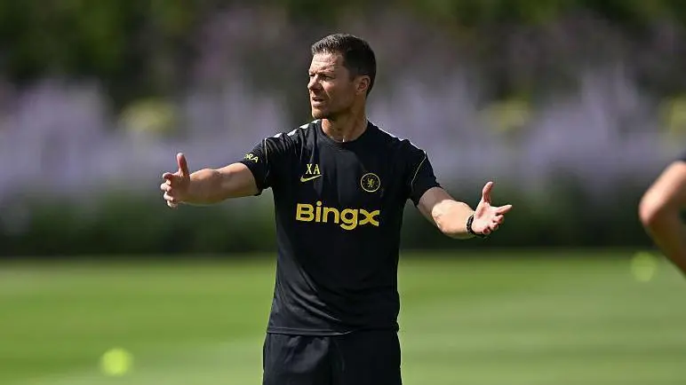 Xabi Alonso directing a training session in a black kit at a football field.