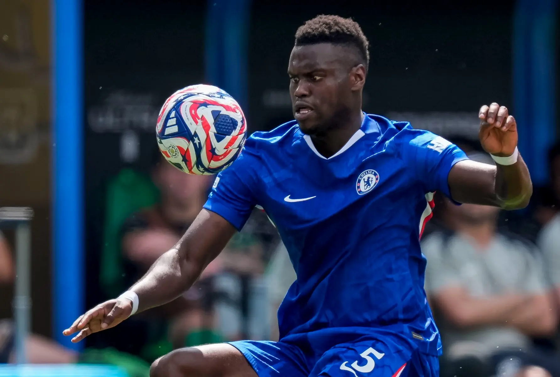 Benoit Badiashile in a blue Chelsea FC kit controlling a football with his chest during a match.