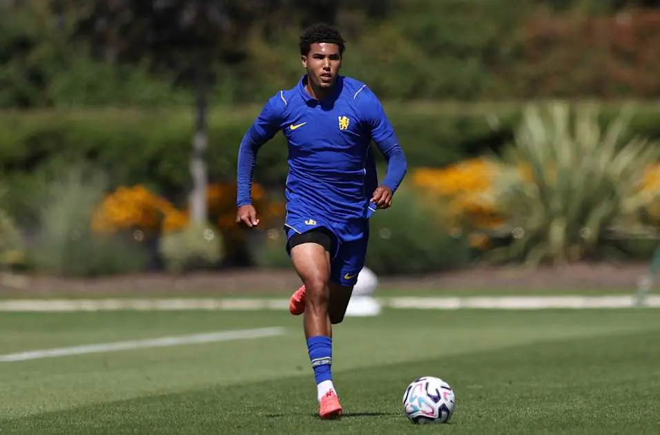 Caleb Wiley training on a grass pitch wearing a blue Chelsea FC training kit and red boots