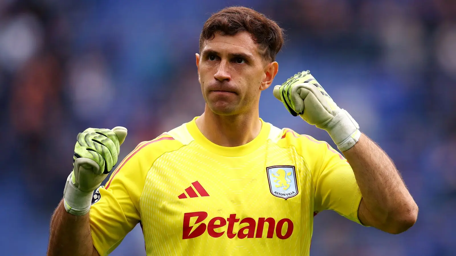 Aston Villa goalkeeper Emiliano Martinez wearing a yellow goalkeeper kit and gloves