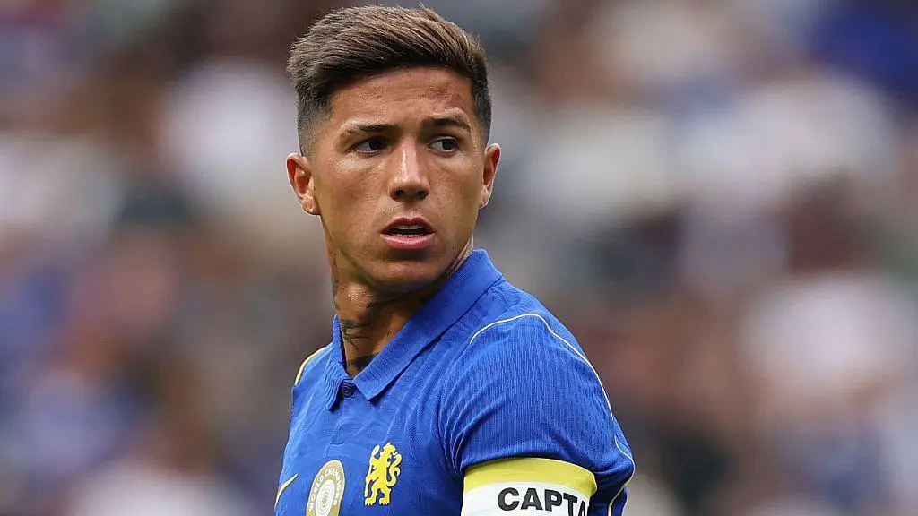 Enzo Fernandez wearing a Chelsea FC blue home kit with a captain's armband