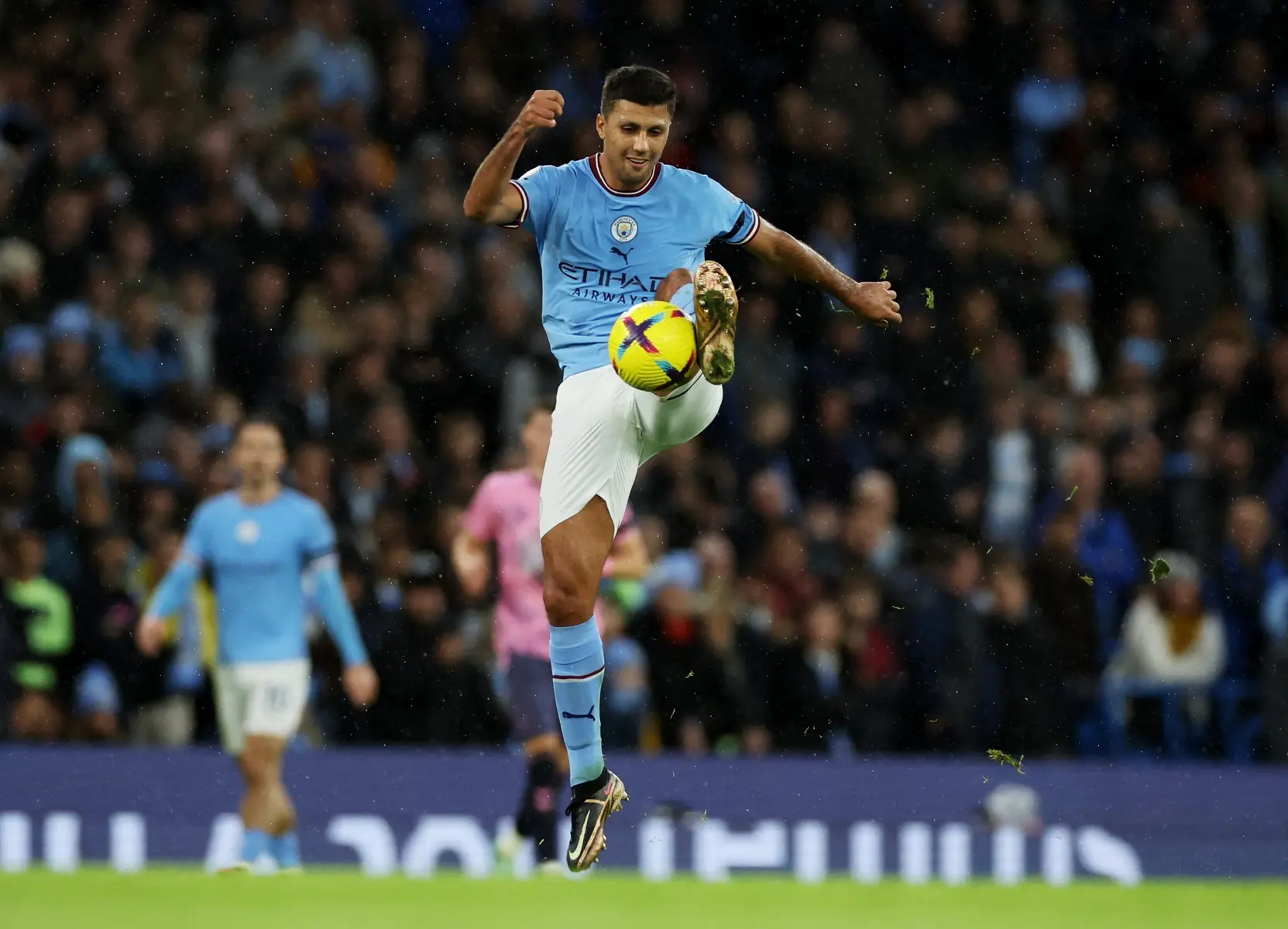 Manchester City midfielder Rodri controlling a football mid-air during a match