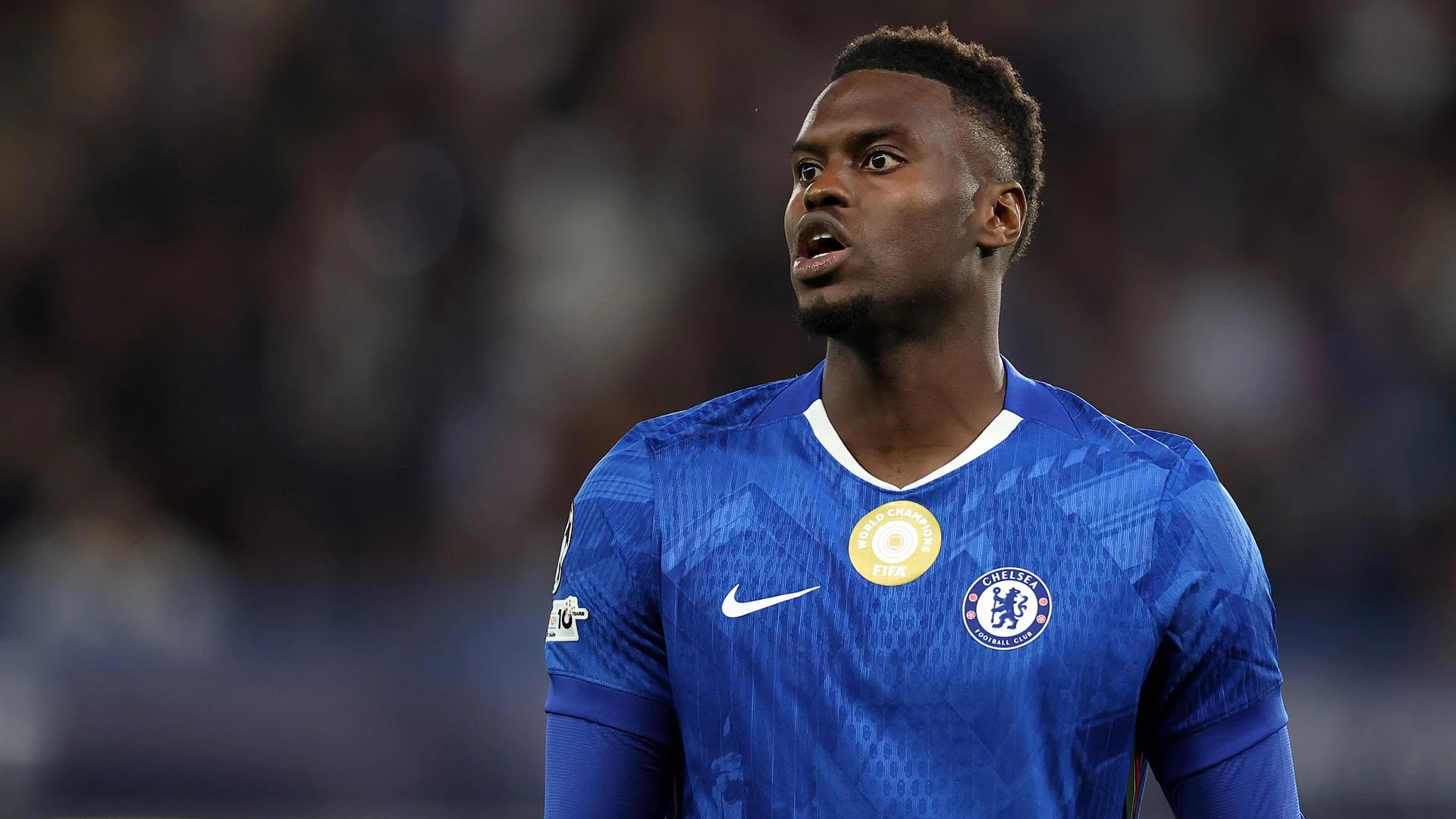 Benoit Badiashile wearing a blue Chelsea FC jersey with a FIFA World Champions badge.