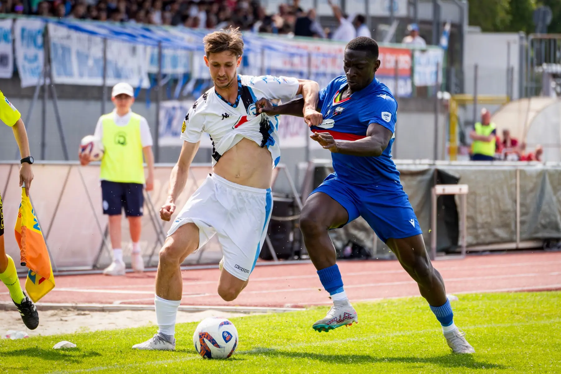 Emmanuel Emegha in a blue kit competing for the ball against an opponent in a white and black kit