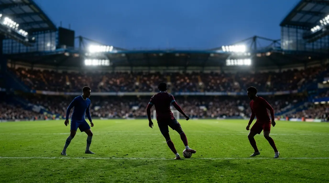 Anonymous midfielders on a stadium pitch representing Chelsea and Liverpool competing for Manu Kone