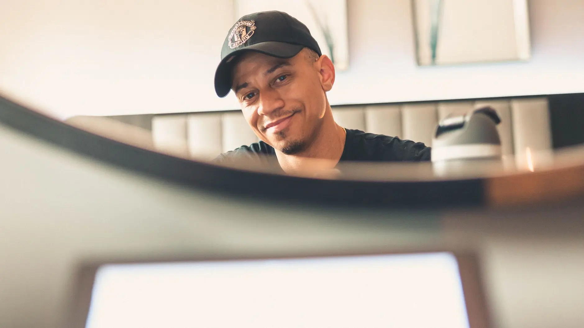 Reece James wearing a black Chelsea FC baseball cap and smiling