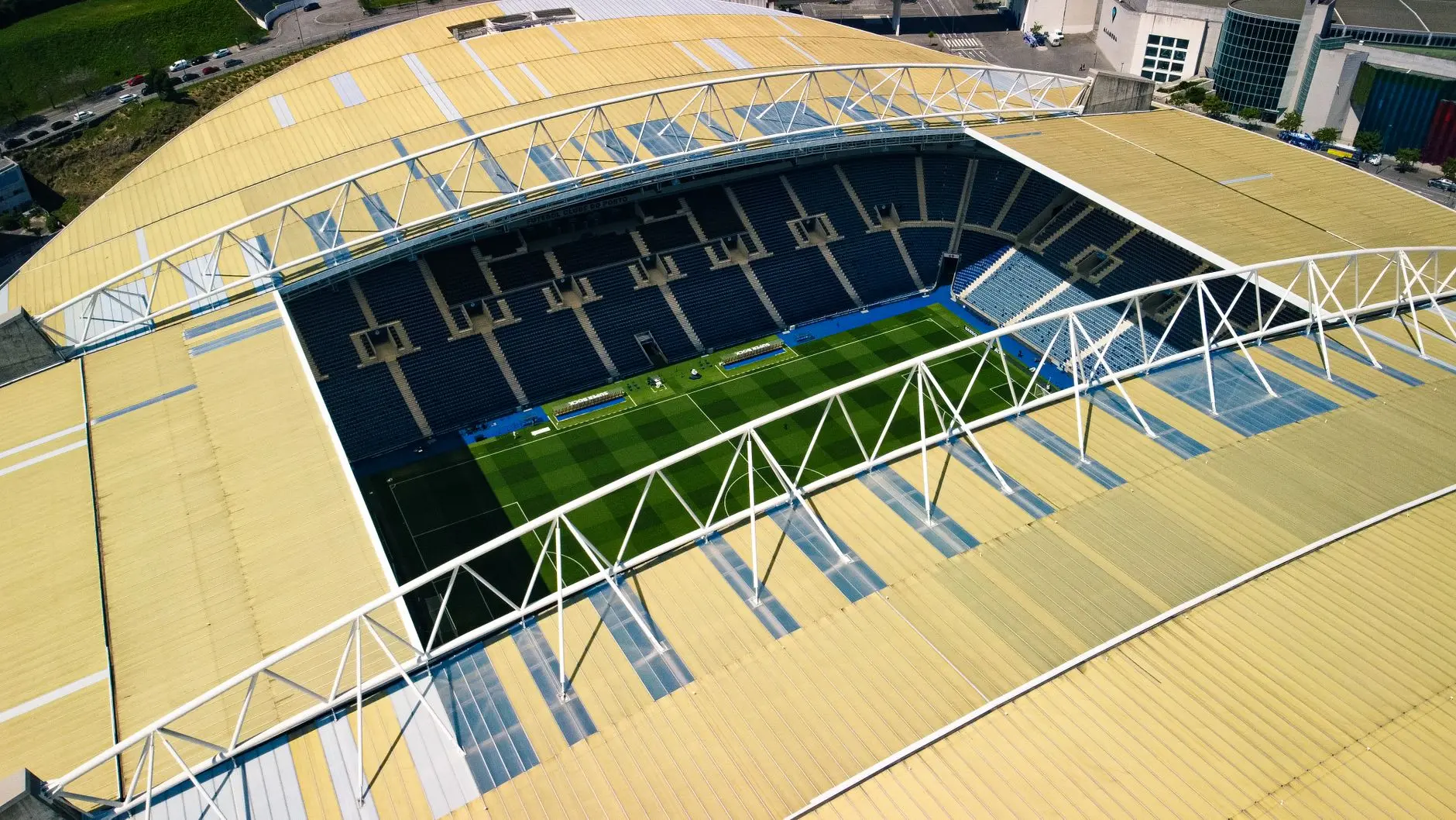 Aerial view of the Stamford Bridge stadium pitch and stands under a yellow roof structure