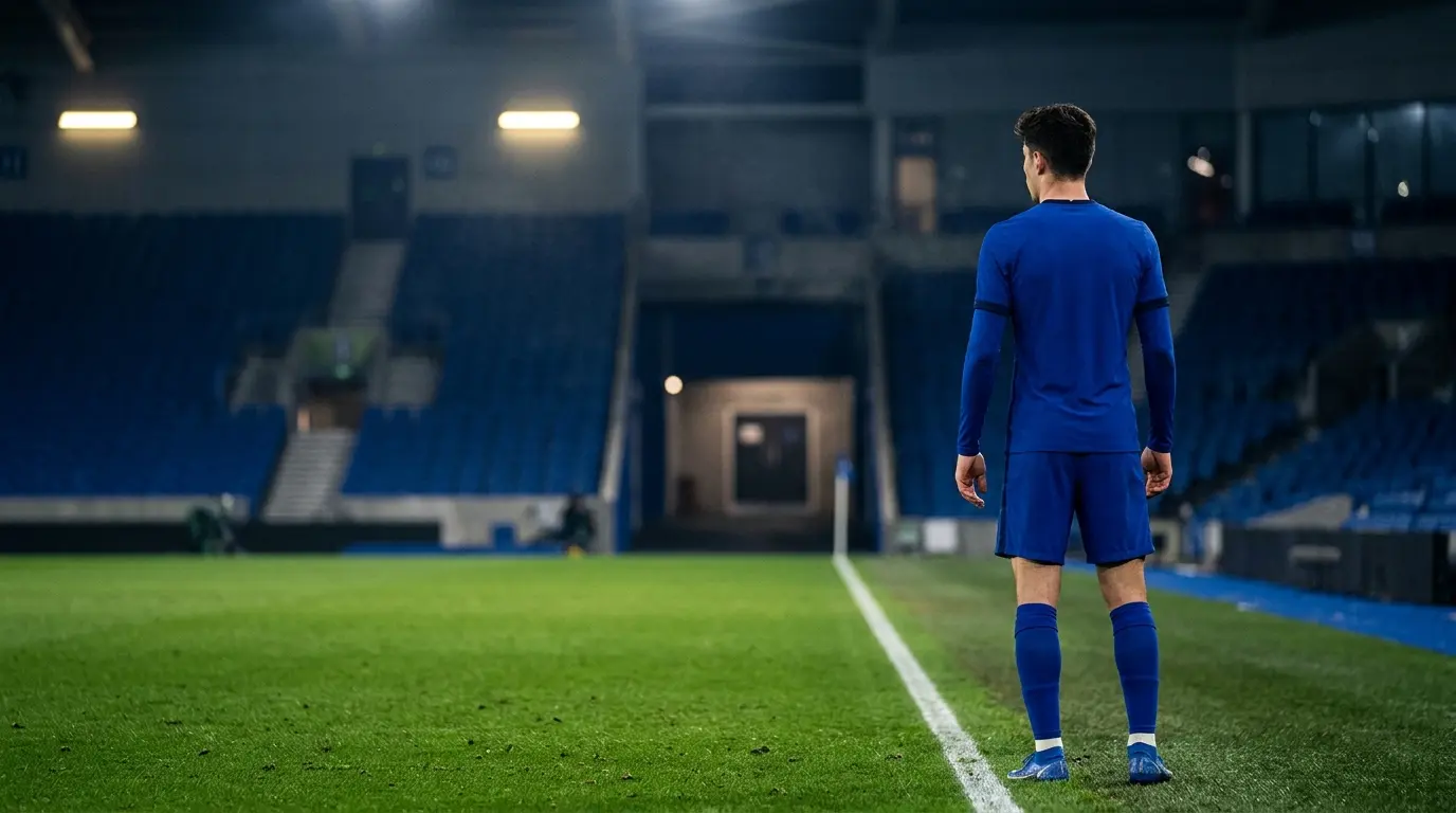 Footballer in a blue kit watches a stadium tunnel, symbolising a delayed Chelsea transfer move