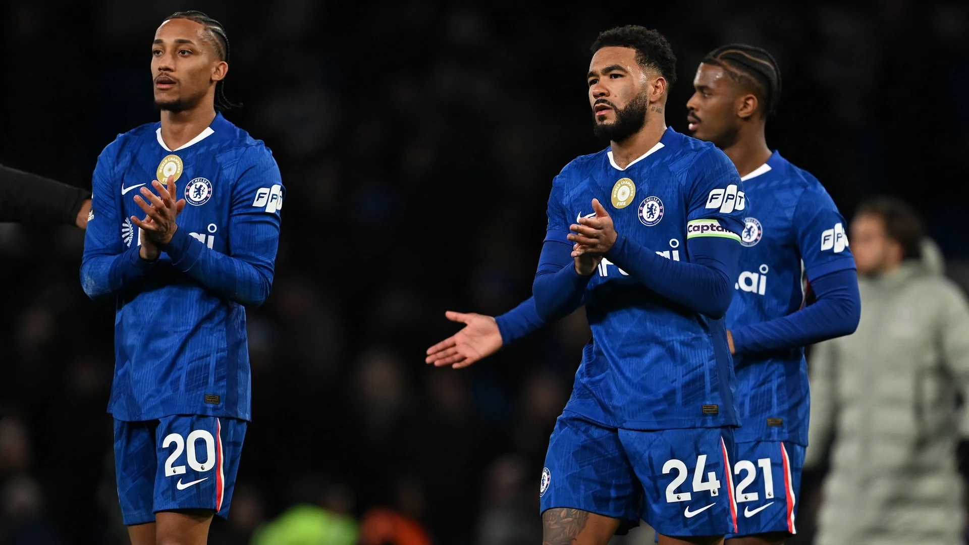 Chelsea football players in blue home kits on the pitch during a match.