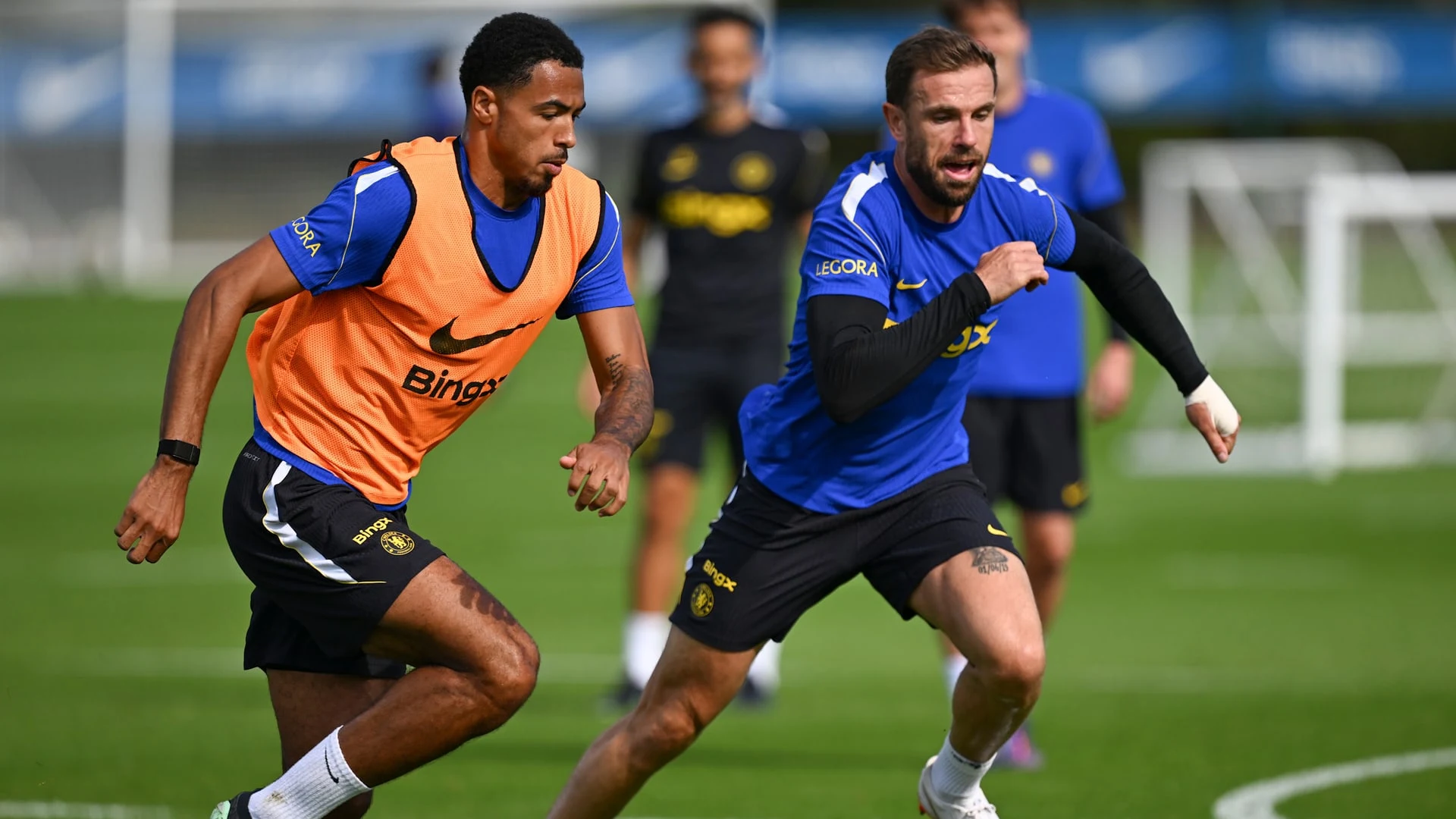 Chelsea FC players training on a grass pitch at Cobham.